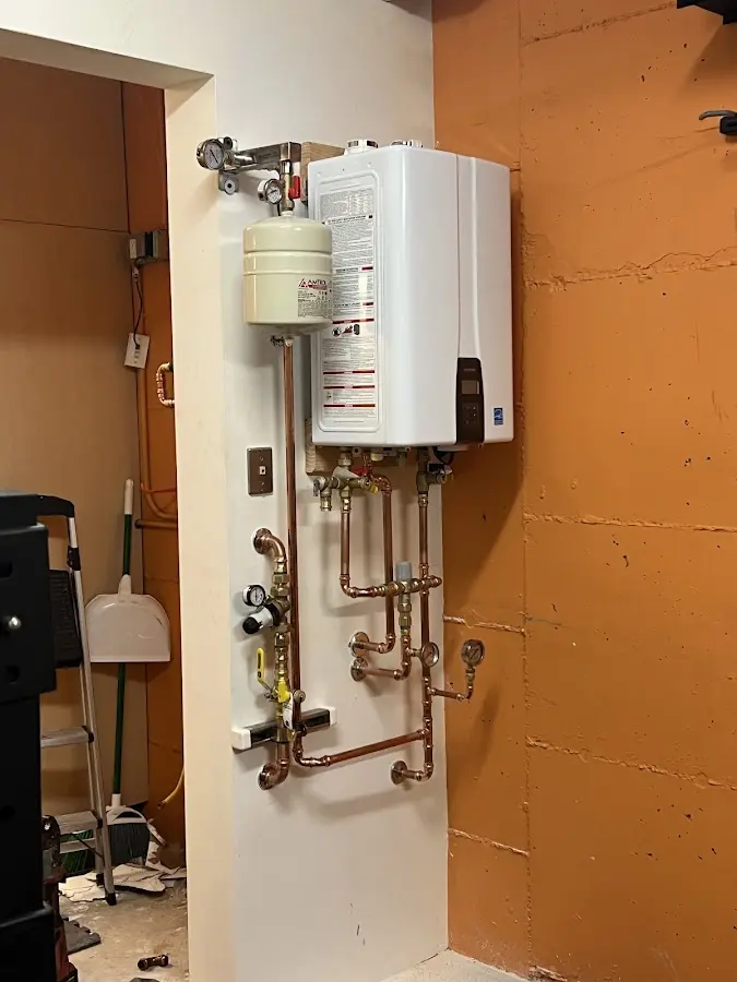 Plumbing technician inspecting water heater connections in Thurmont